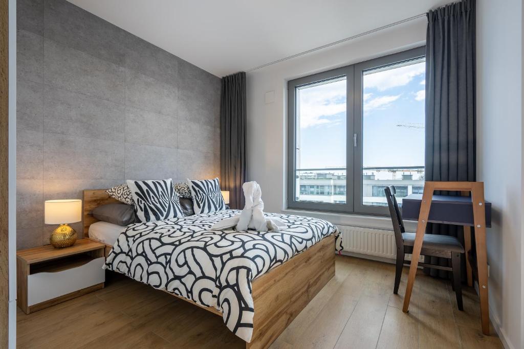 ein Schlafzimmer mit einem Bett und einem großen Fenster in der Unterkunft 04 Gdynia Premium - Apartament Mieszkanie dla 2 osób z parkingiem in Gdynia