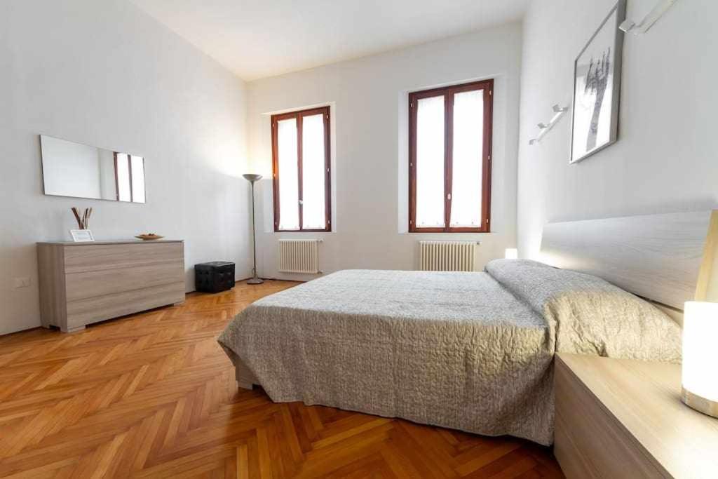 um quarto com uma cama, uma cómoda e janelas em Toniolo venice rooms em Mestre