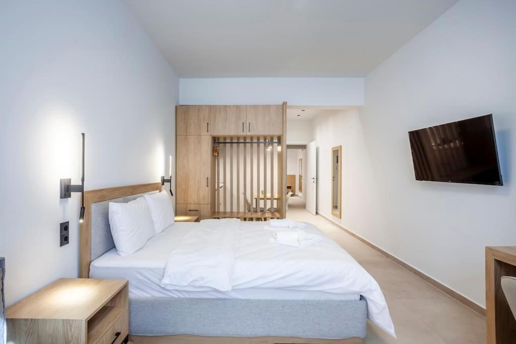 a bedroom with a large white bed and a flat screen tv at FsN Central Lofts 303 /2bed / 5P in Thessaloniki