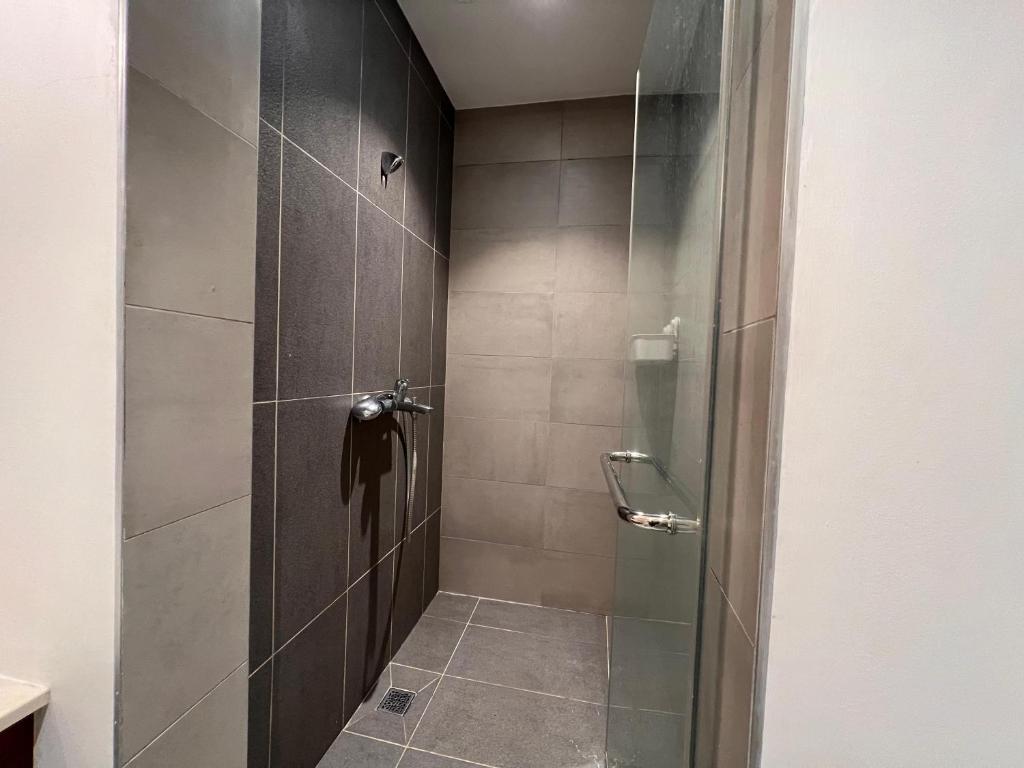 a shower with a glass door in a bathroom at Ebene Square apartment in Trianon