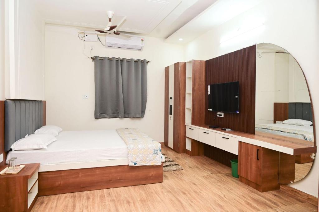 sypialnia z łóżkiem i lustrem w obiekcie Green park w mieście Waranasi