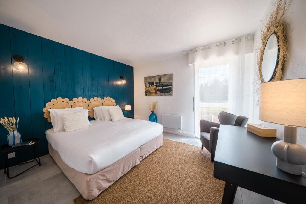 Un dormitorio con una gran cama blanca y una pared azul. en Hôtel de la Brière et Restaurant Les Krapados, en Saint-Lyphard
