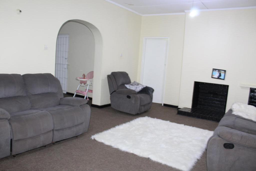 sala de estar con 2 sofás y chimenea en Cozy Paradise Apartment en Lilongüe