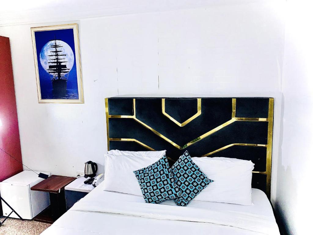 a bedroom with a bed with a black and gold headboard at Vintage Classic Lodge in Lagos