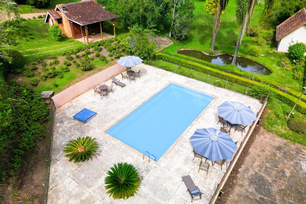 una vista aérea de una piscina con sombrillas en VELINN Hotel Fazenda Fonte das Hortênsias, en Santo Antônio do Pinhal