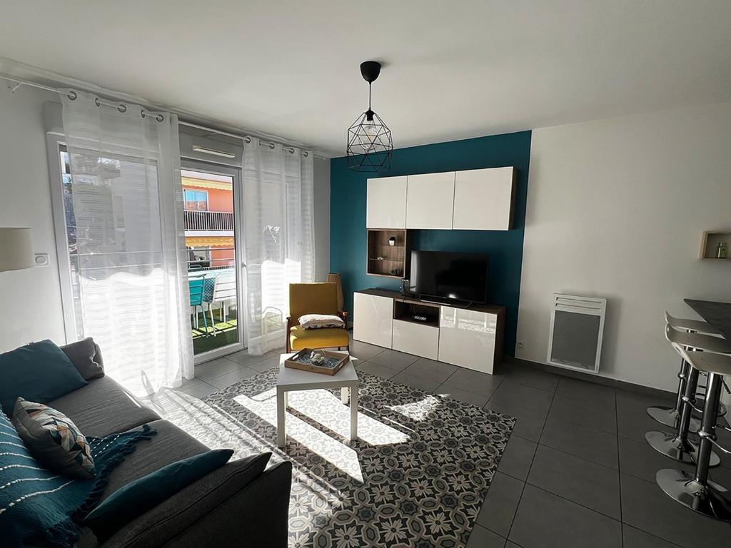 een woonkamer met een bank en een tafel bij Douceur en Ville Saint Raphel in Saint-Raphaël