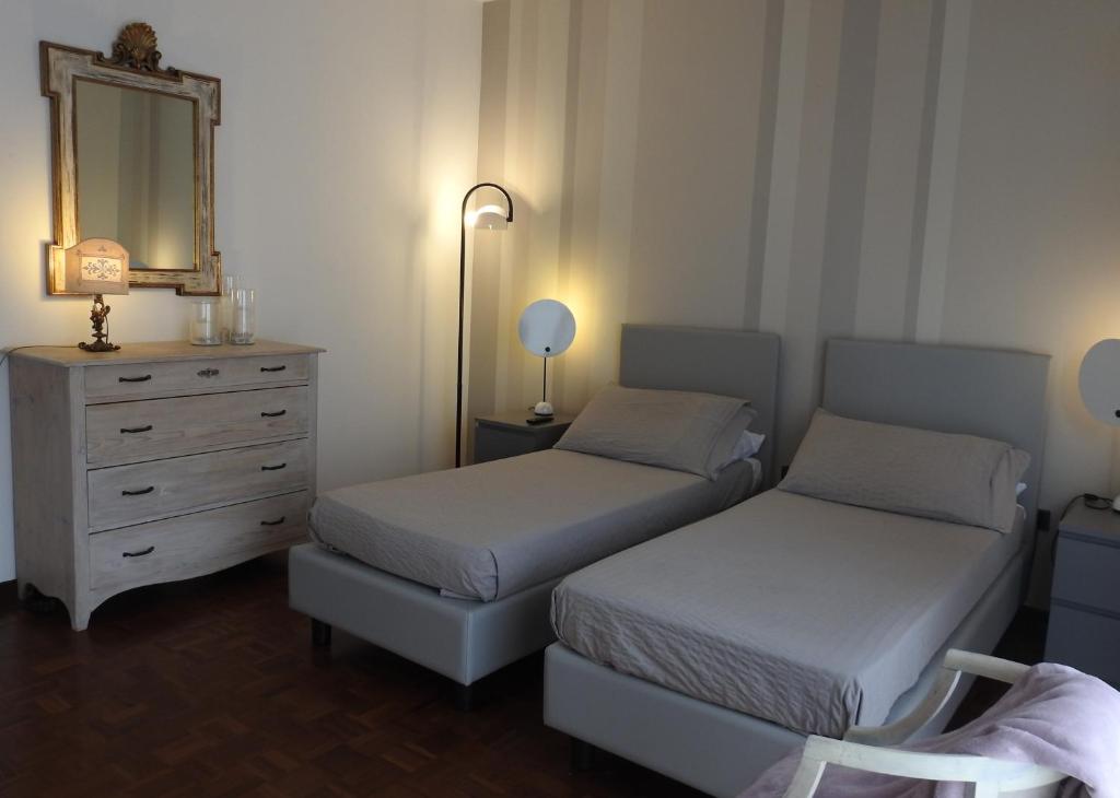 sypialnia z 2 łóżkami, komodą i lustrem w obiekcie La casa di Clara w mieście Esine
