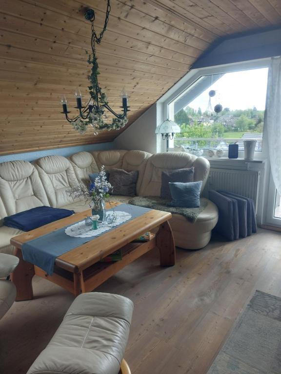 uma sala de estar com um sofá e uma mesa em haus krümel em Trippstadt
