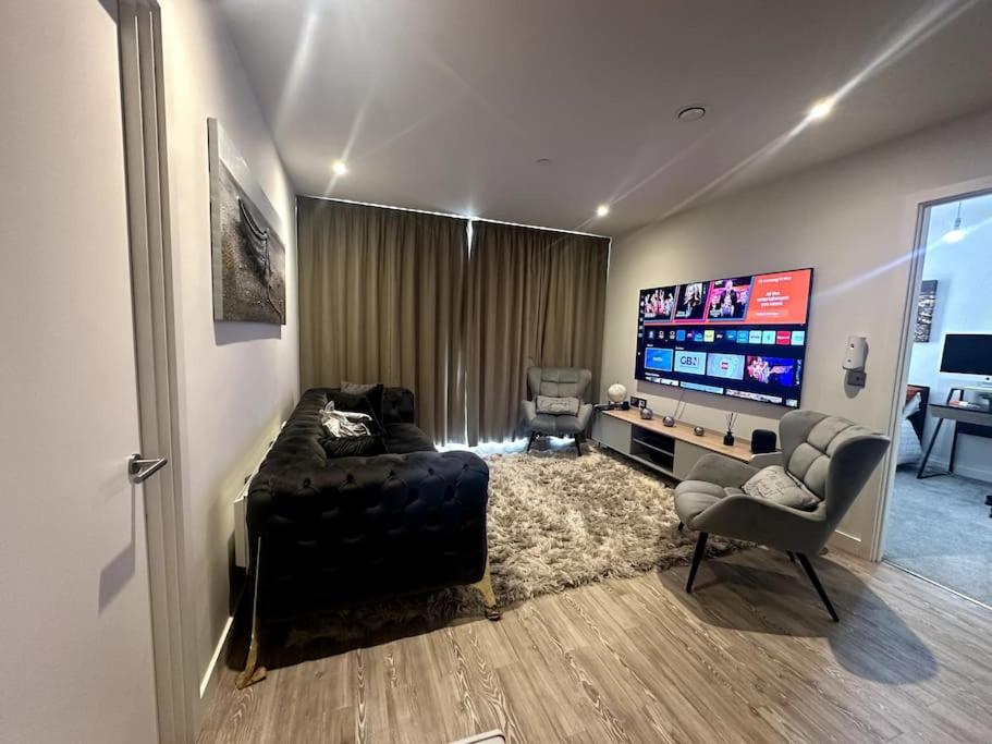 - un salon avec une télévision, un canapé et une chaise dans l'établissement RJO Apartments Chatham, à Brompton
