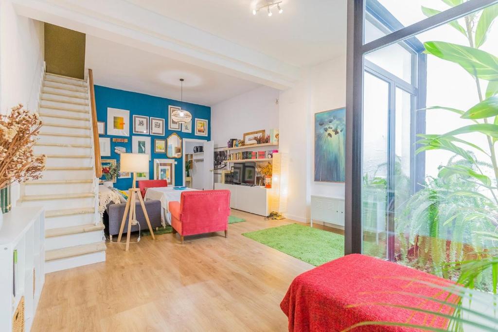 ein Wohnzimmer mit einem Tisch und roten Stühlen in der Unterkunft Tu estancia perfecta en Sevilla in Sevilla