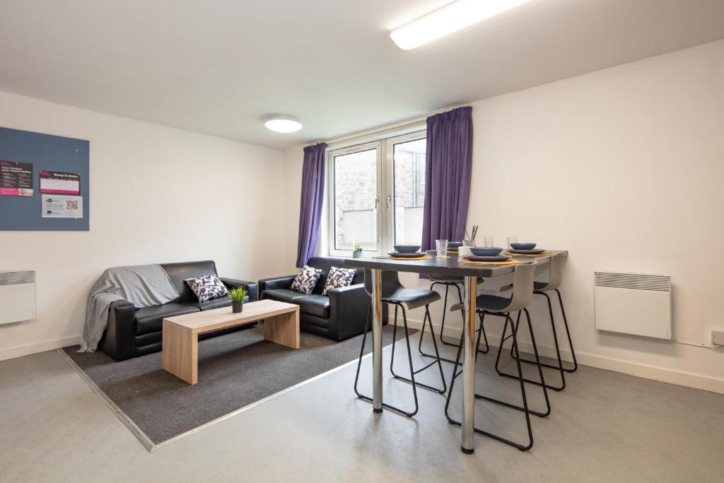 - un salon avec une table et un canapé dans l'établissement Charming Aberdeen Adult-Only Flats, à Aberdeen
