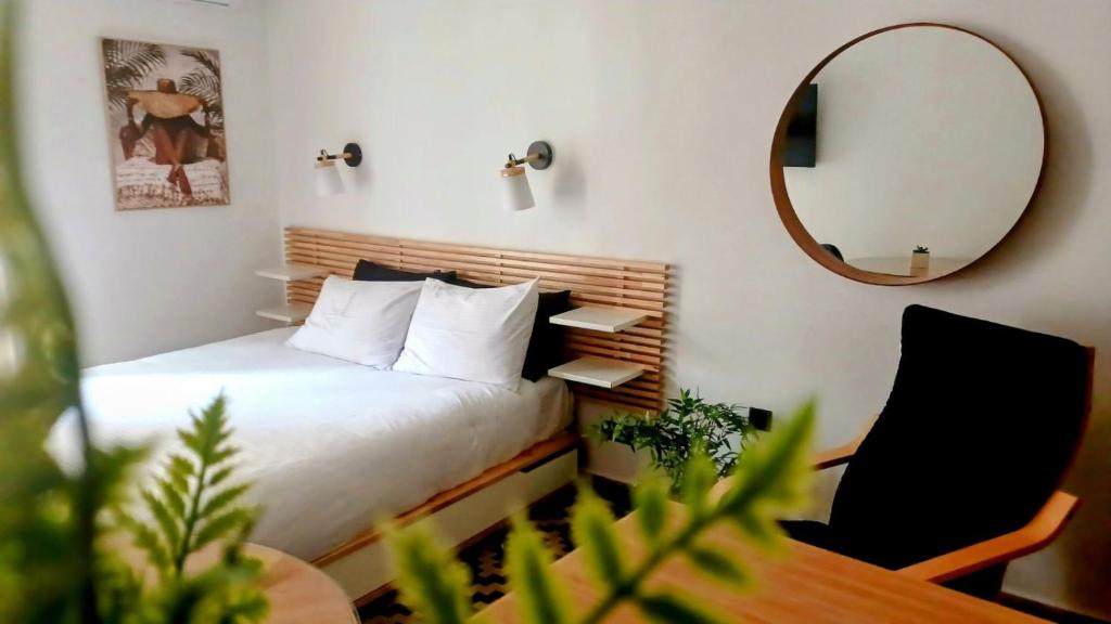1 dormitorio con cama, espejo y silla en brand new studio 2, en Komotiní