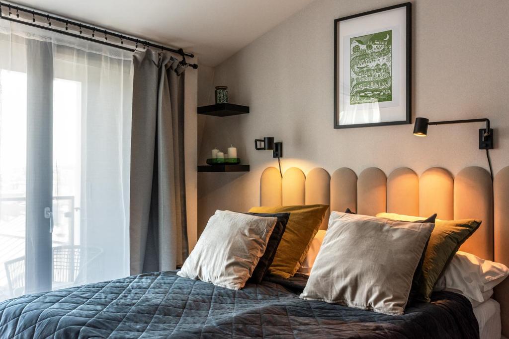 een slaapkamer met een bed met 2 kussens en een raam bij Iron Apartments in Krakau