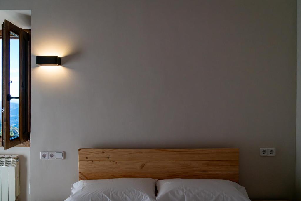 - une chambre avec un lit éclairé au mur dans l'établissement Santuari de Santa Maria de Montgrony, à Gombreny