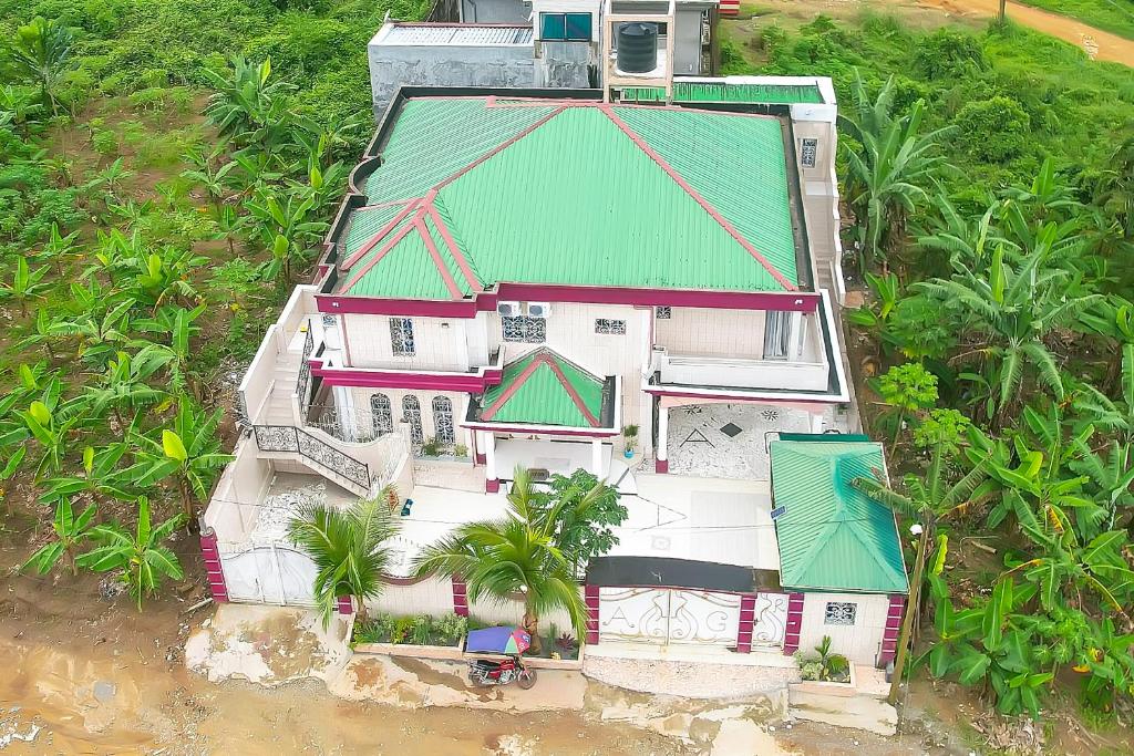 une vue aérienne sur une maison avec un toit vert dans l'établissement Ajieh Rest House, à Douala