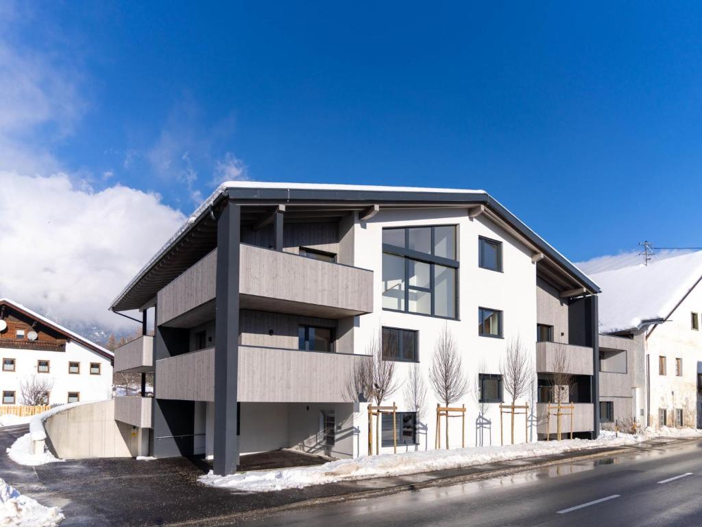 a large white building on the side of a street at Apartment be blue by Interhome in Mieming