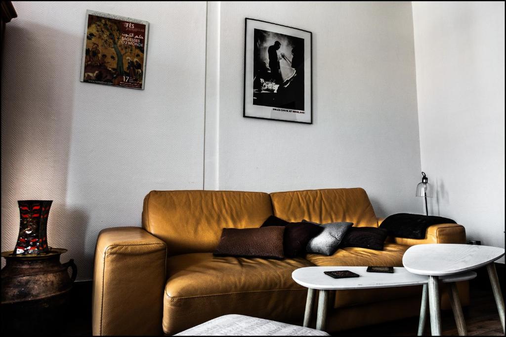 a living room with a brown couch and a table at Au kouglof avec Netflix in Colmar