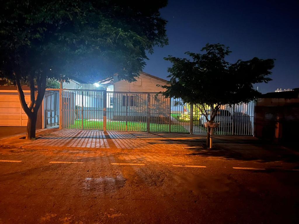 a fence in front of a building with a tree at Casa da Vó Maria Suite Dupla 09 in Goiânia