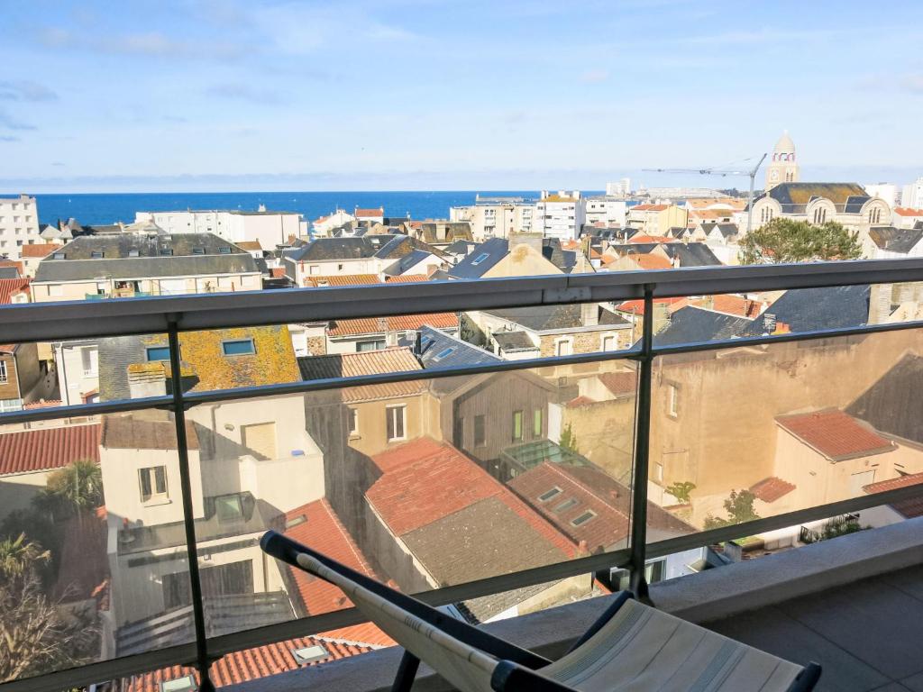 une chaise sur un balcon avec vue sur la ville dans l'établissement Apartment L'Hippocampe T2 balcon et large vue mer by Interhome, à Les Sables-dʼOlonne