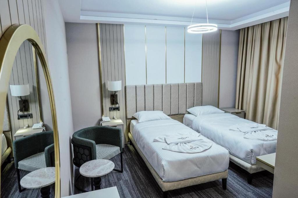 伊斯坦堡的住宿－ONKA OTELCİLİK TURİZM TİCARET LİMİTED ŞİRKETi，酒店客房,设有两张床和镜子
