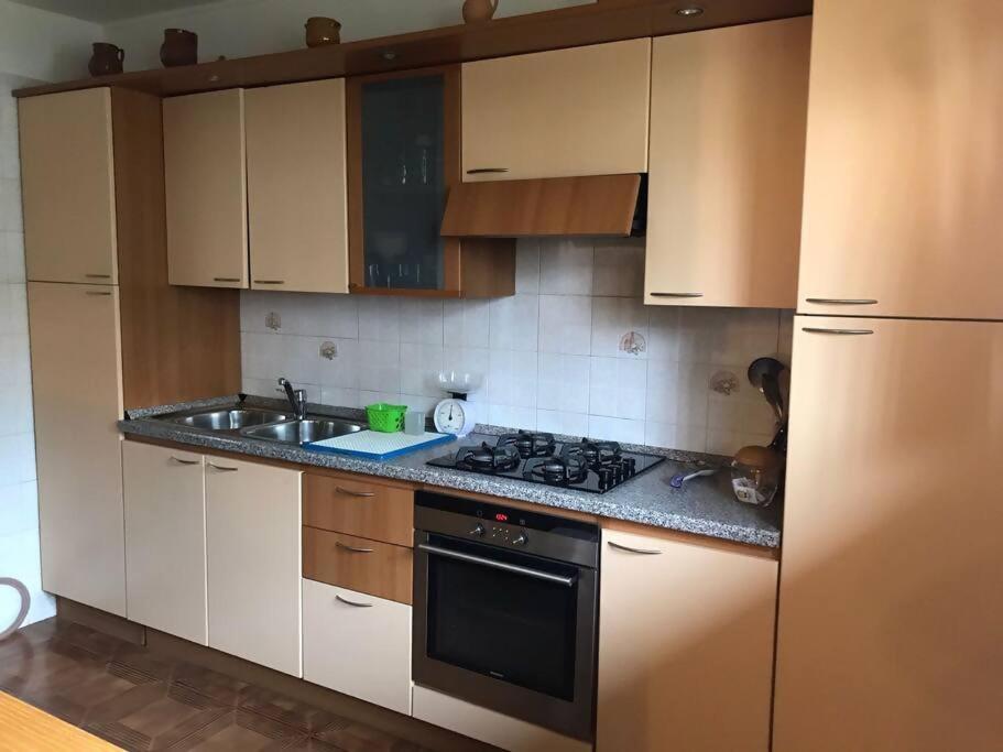 a kitchen with white cabinets and a stove and a sink at City e Airport BGY in Bergamo