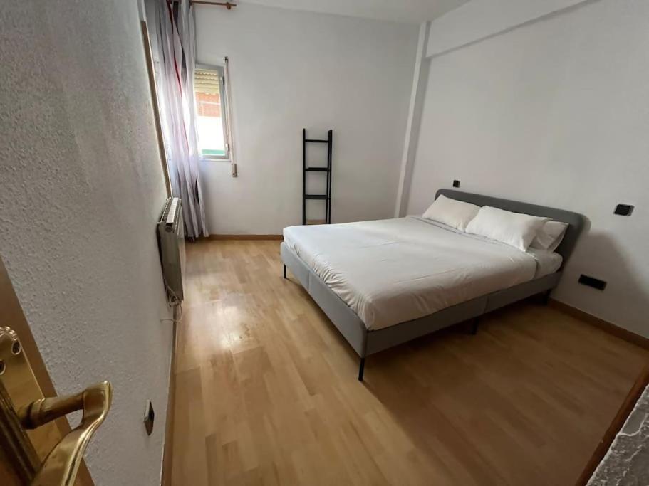 Schlafzimmer mit einem Bett und Holzboden in der Unterkunft Piso junto al Madrid Río in Madrid