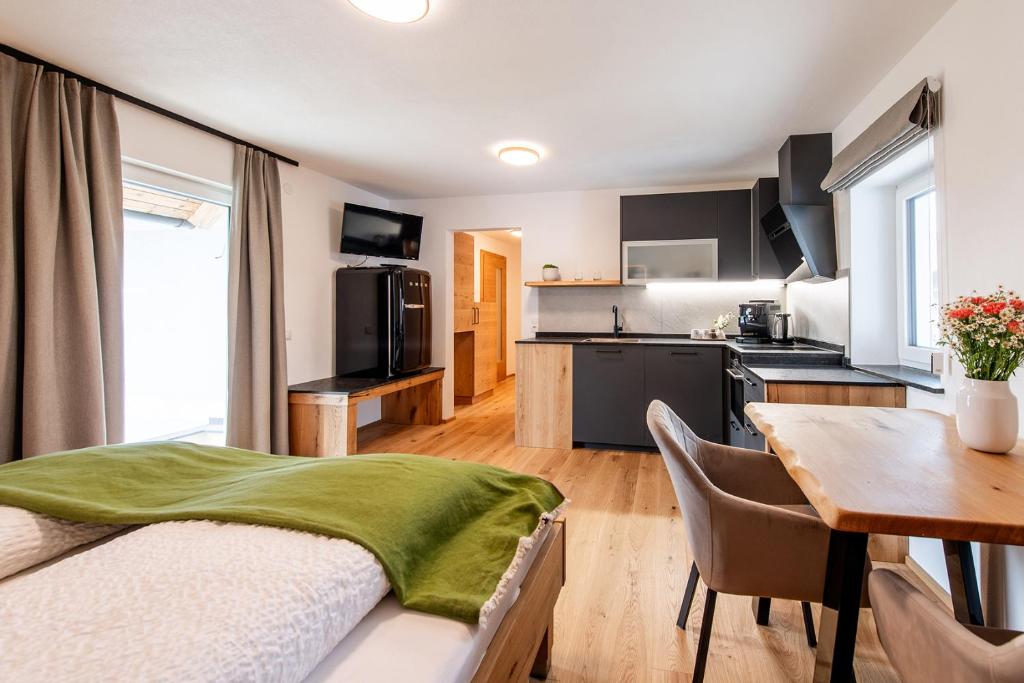 a bedroom with a kitchen and a table with a bed at Biohof Greflgut in Vöcklamarkt
