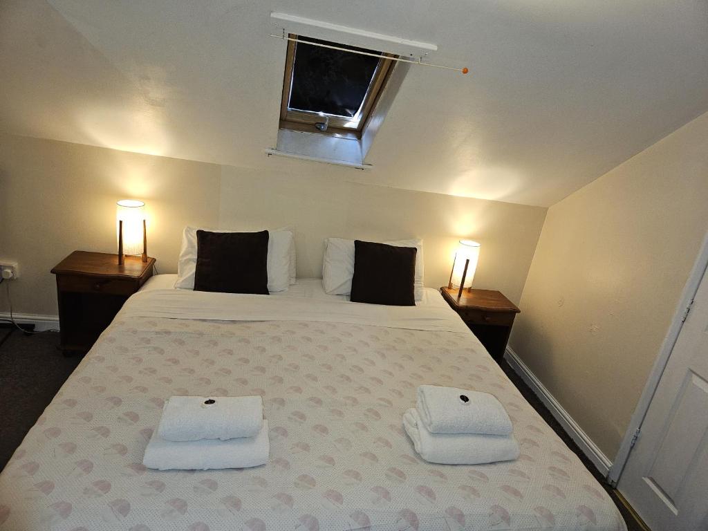- une chambre avec un lit et 2 serviettes dans l'établissement Rose Marie Guest House, à Peterborough