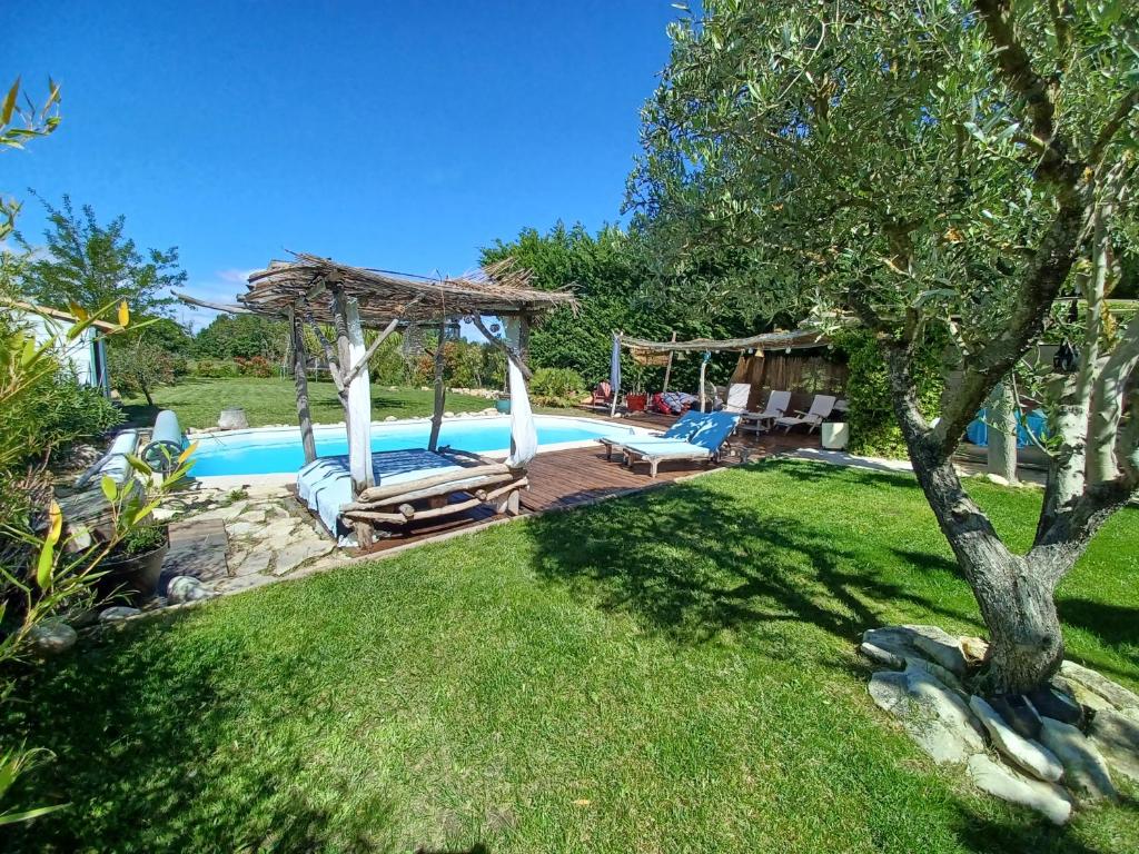 einen Hinterhof mit einem Pool mit Pavillon in der Unterkunft Maison climatisée en campagne, terrasses couvertes grand jardin ombragé et piscine in Aix-en-Provence