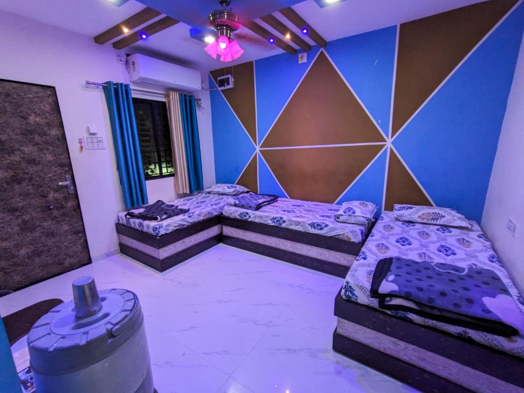 a room with two beds and a wall at Infinity Luxury Homestay in Garudeshwar