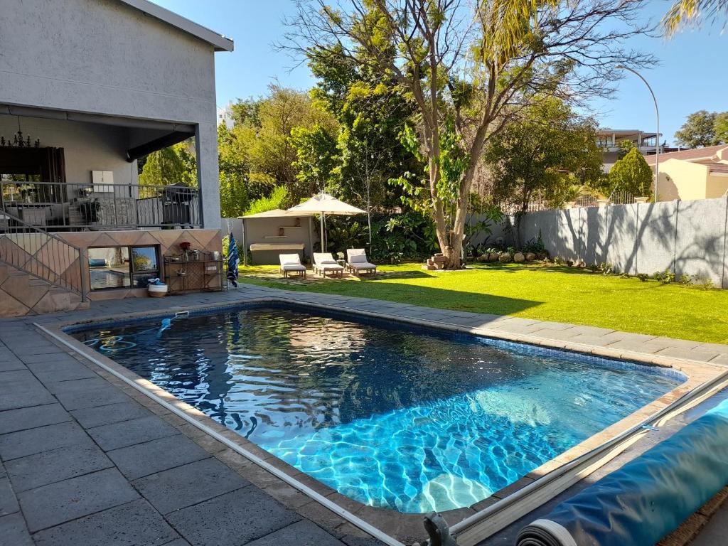 a swimming pool in the backyard of a house at Safari Villa Botique Hotel in Windhoek