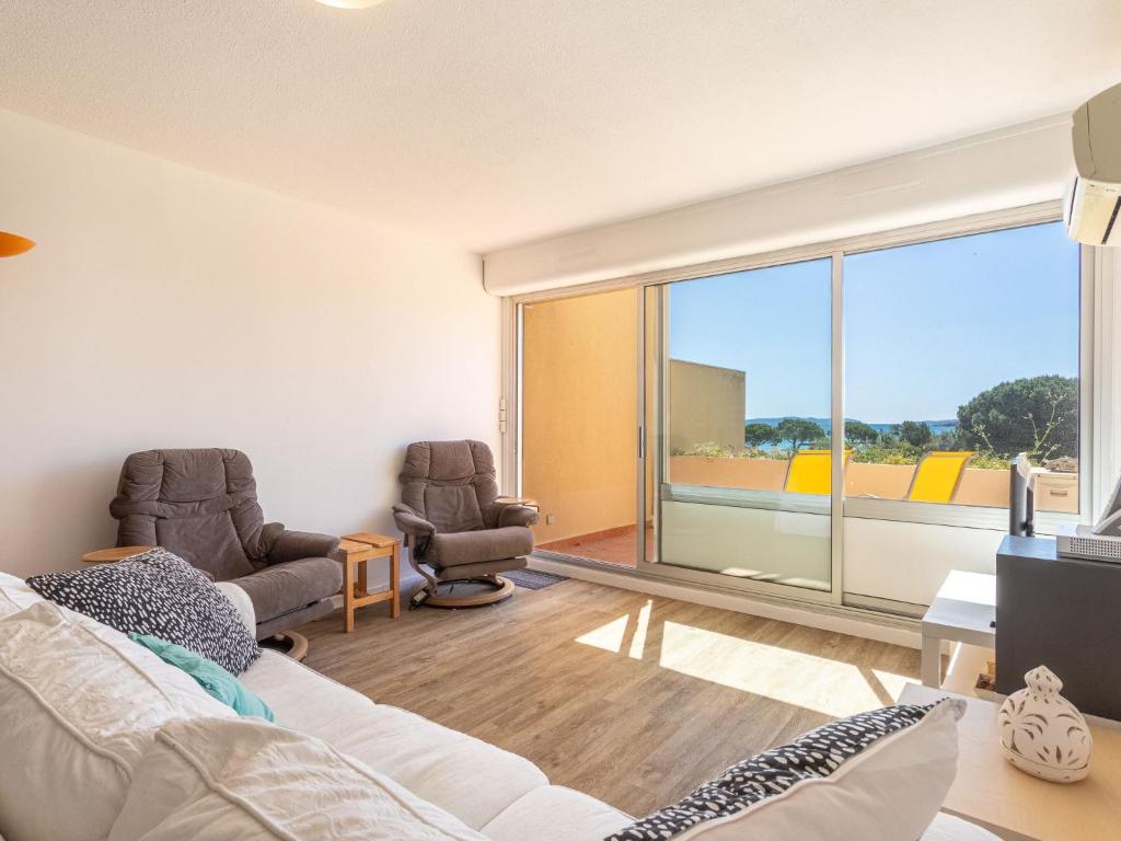 un salon avec un canapé et deux chaises dans l'établissement Apartment Les Ondines by Interhome, à Bormes-les-Mimosas