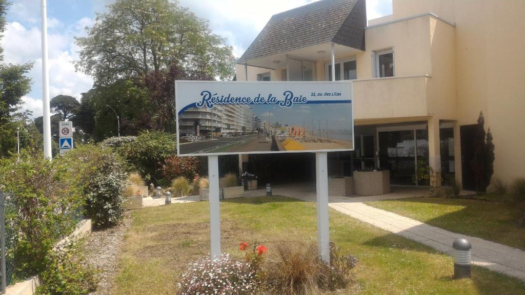 un panneau dans l'herbe devant un bâtiment dans l'établissement La Baule Plage Benoît - Studio 25m, 4 personnes, Balcon, à La Baule
