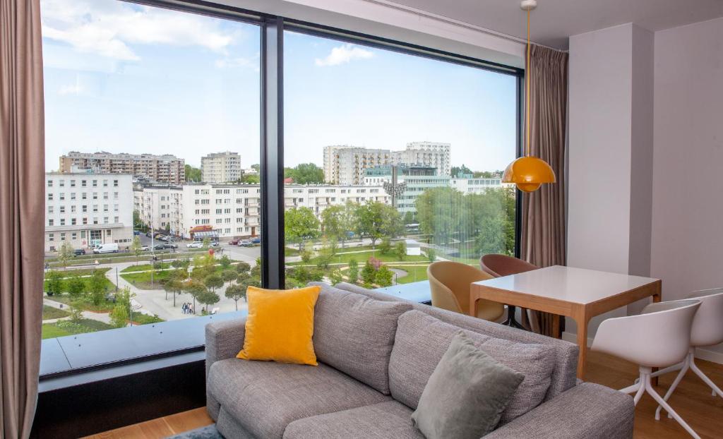 a living room with a couch and a large window at Aparthotel Park - By The Sea in Gdynia