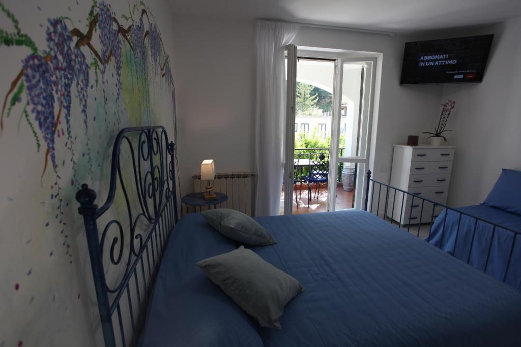 a bedroom with a blue bed with a map on the wall at Jungle Rooms in Cetara