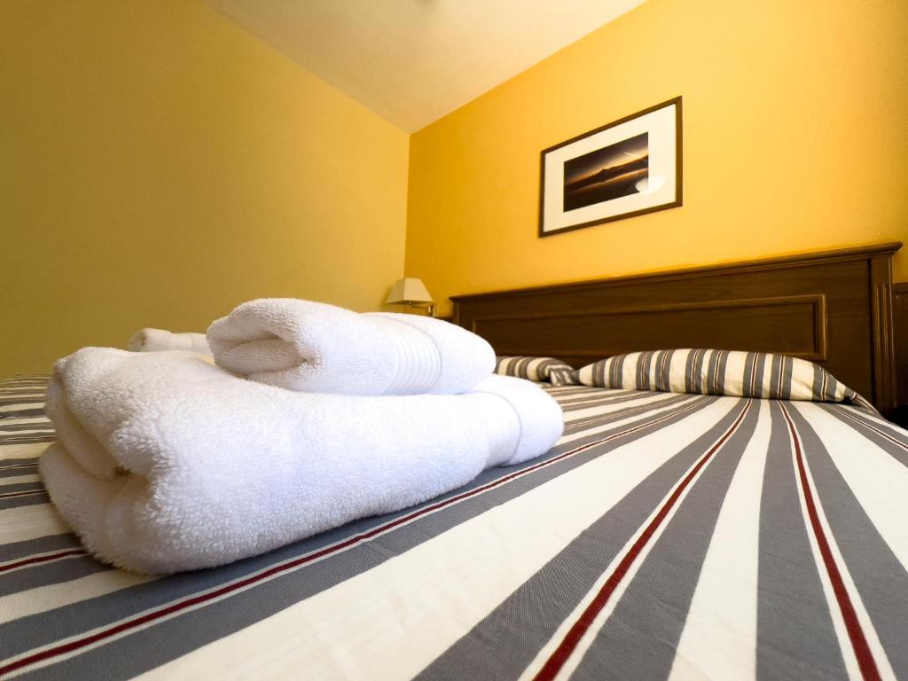 a pile of towels sitting on top of a bed at Complejo Las Tres Palmeras in Valle Gran Rey