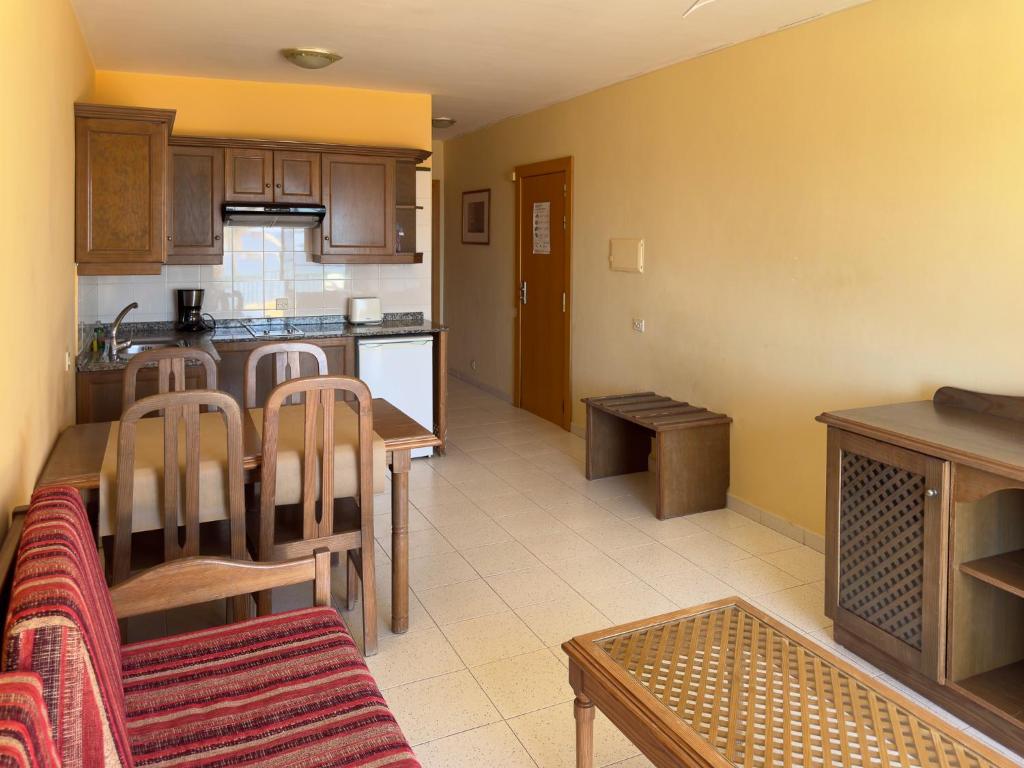a kitchen and living room with a table and chairs at Complejo Las Tres Palmeras in Valle Gran Rey