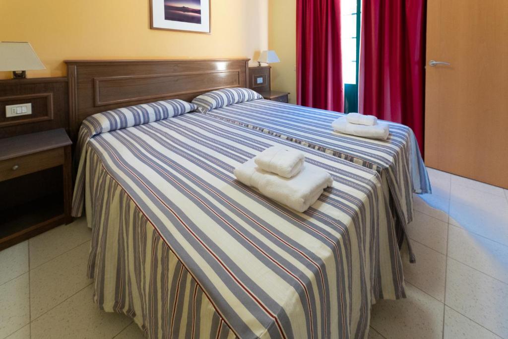 a bed with two towels on top of it at Complejo Las Tres Palmeras in Valle Gran Rey