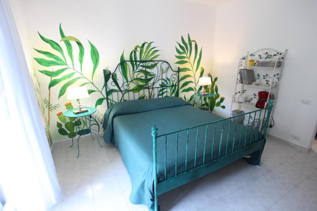 a bedroom with a bed with plants on the wall at Jungle Rooms in Cetara