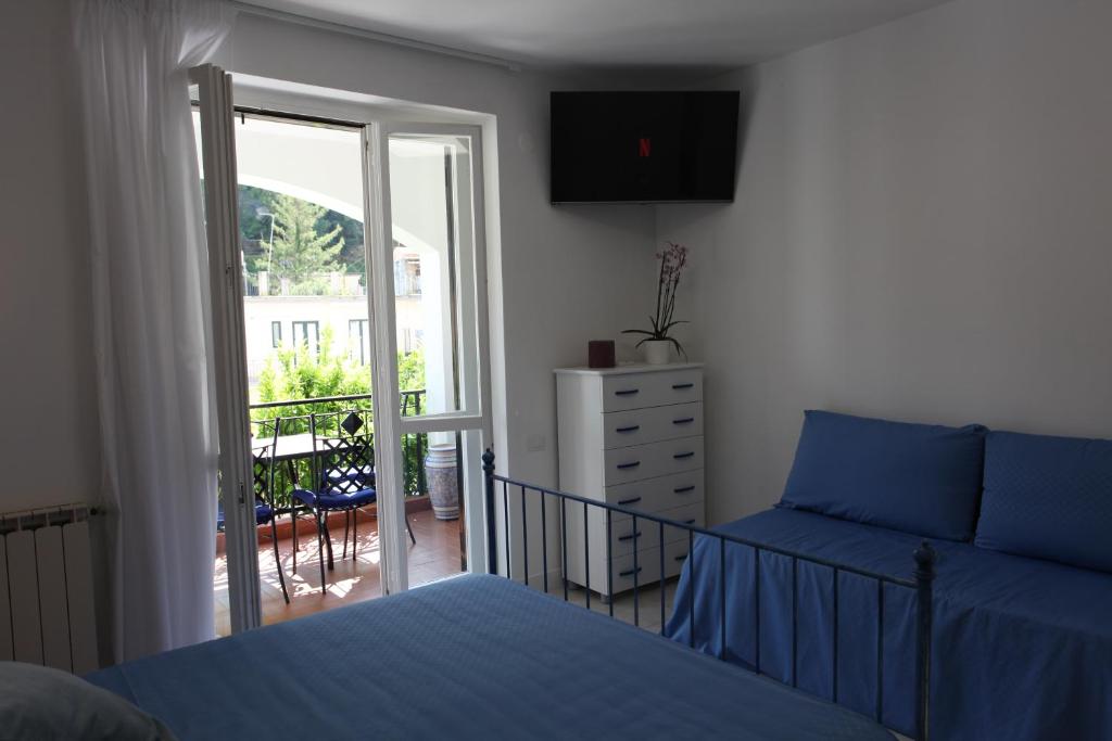 a bedroom with a bed and a door to a balcony at Jungle Rooms in Cetara