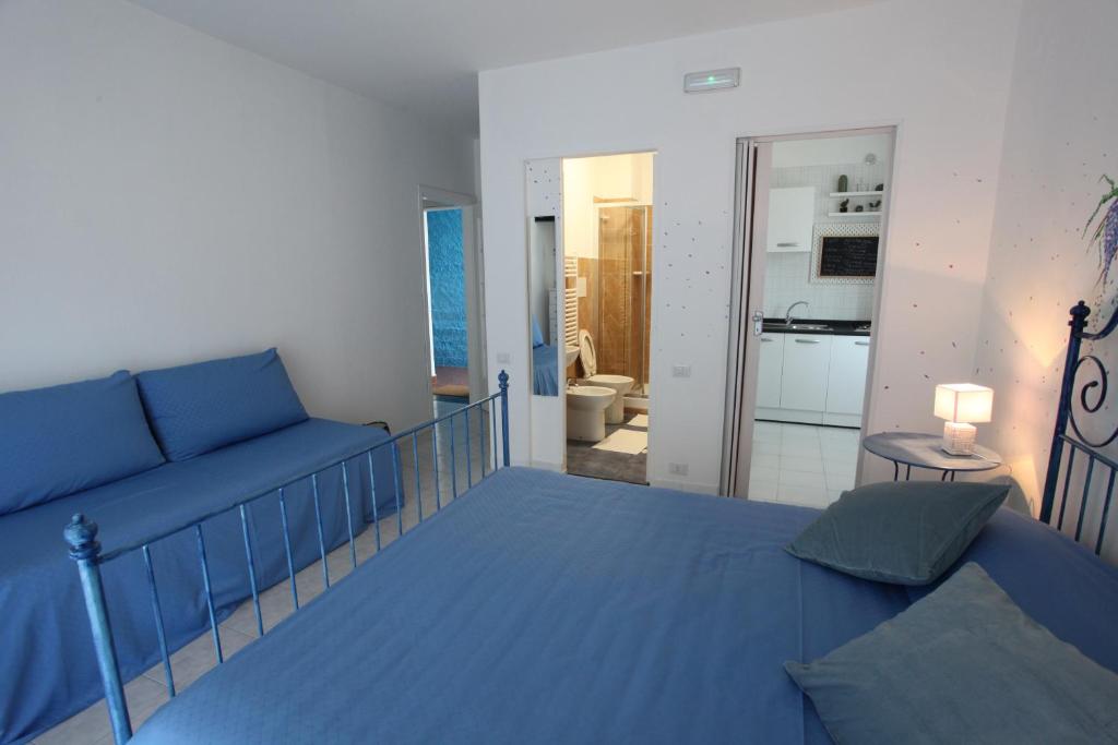 a blue bed and a couch in a room at Jungle Rooms in Cetara