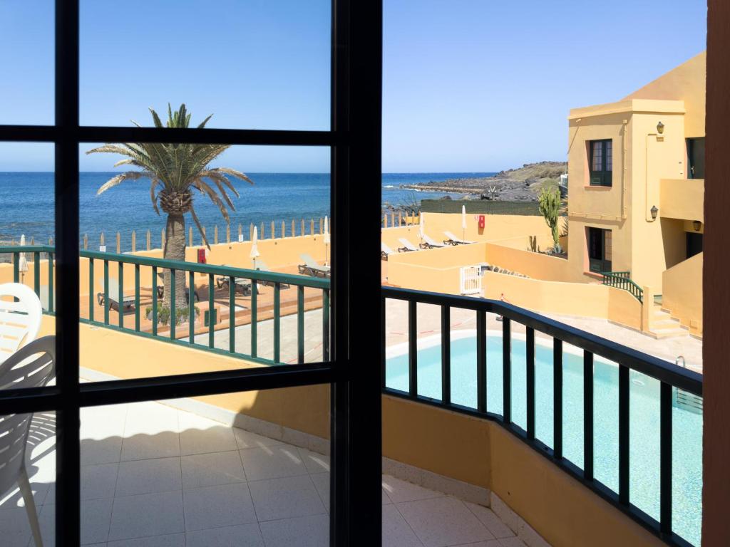 a view of the beach from the balcony of a resort at Complejo Las Tres Palmeras in Valle Gran Rey