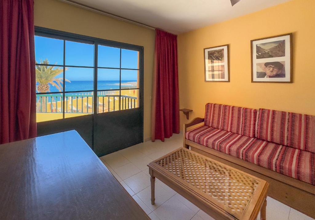 a living room with a couch and a view of the ocean at Complejo Las Tres Palmeras in Valle Gran Rey