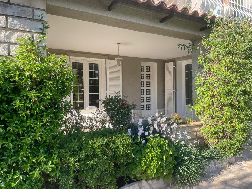 une maison avec des buissons et des fleurs devant dans l'établissement T2 en rez de villa, à Sanary-sur-Mer