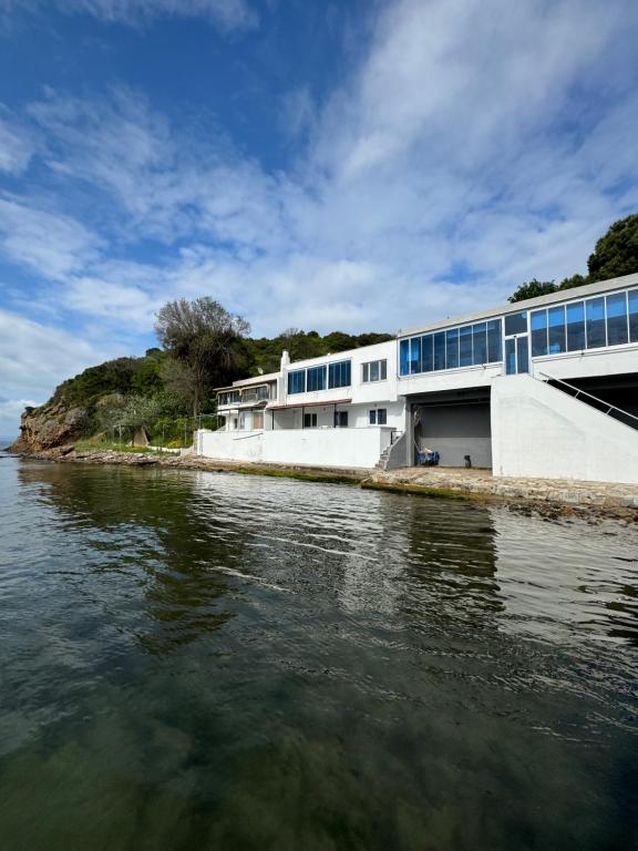 un bâtiment à côté d'une masse d'eau dans l'établissement Hisar Kent deniz evinde denize sıfır bir tatil., à Lapseki