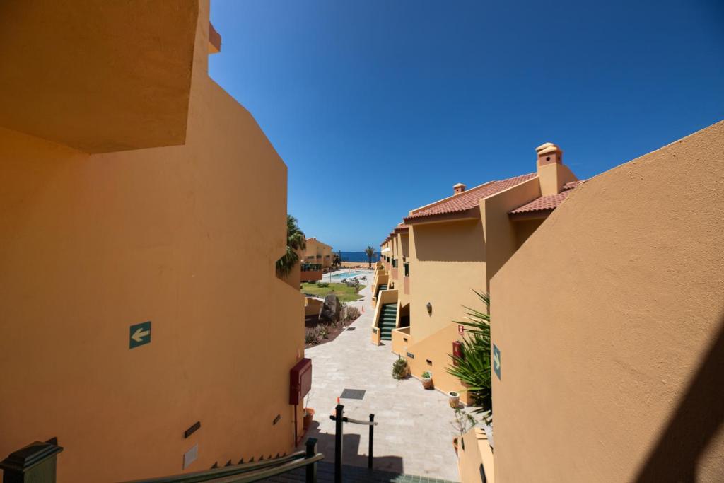 an alleyway between two buildings in a city at Complejo Las Tres Palmeras in Valle Gran Rey