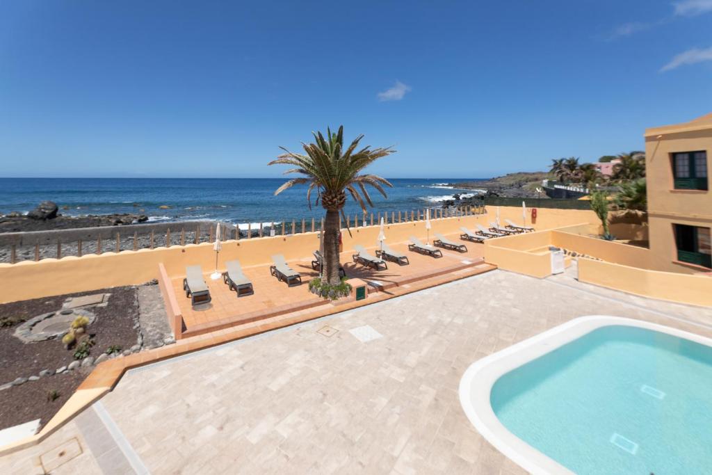 a resort with a swimming pool and a beach at Complejo Las Tres Palmeras in Valle Gran Rey