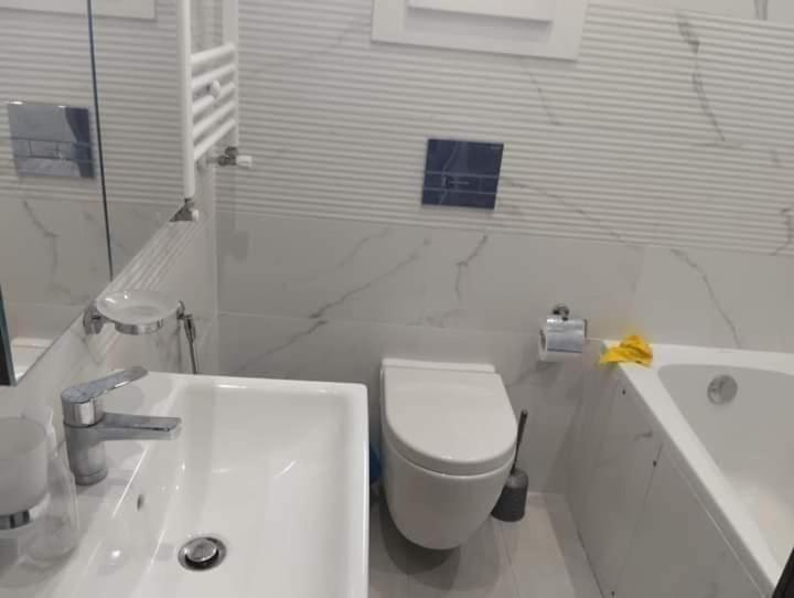 een witte badkamer met een toilet en een bad bij Résidence Sousse in El Ahmar