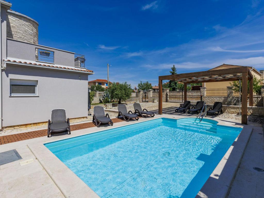 een zwembad met stoelen en een prieel bij Villa Dzana by Interhome in Mednjan