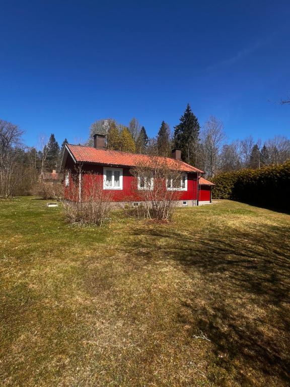 a red house in the middle of a field at Villa Garpenberg in Garpenberg